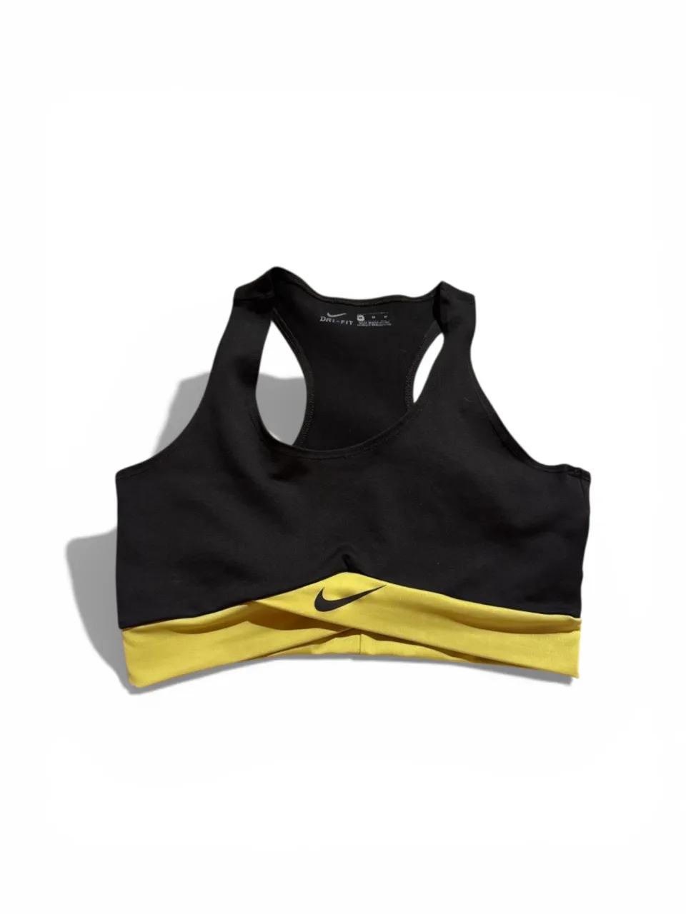 Top deportivo Nike Dri-Fit, ideal para entrenamientos. Diseño moderno en negro con detalles en amarillo vibrante. 
