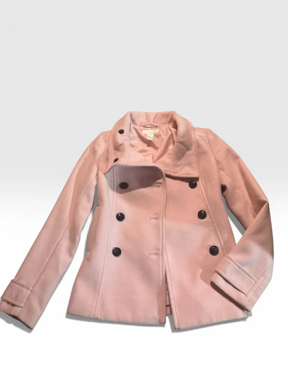 Abrigo rosa tipo peacoat, con doble abotonadura y cuello solapa. Ideal para un look canchero y abrigado.