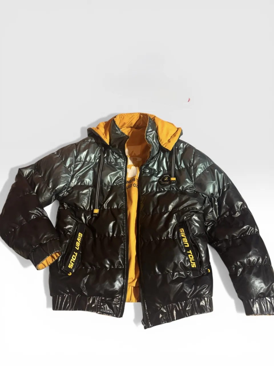 Campera puffer negra brillante, reversible con interior amarillo. Capucha desmontable. Ideal para un look urbano y moderno. unico detalle el cierre