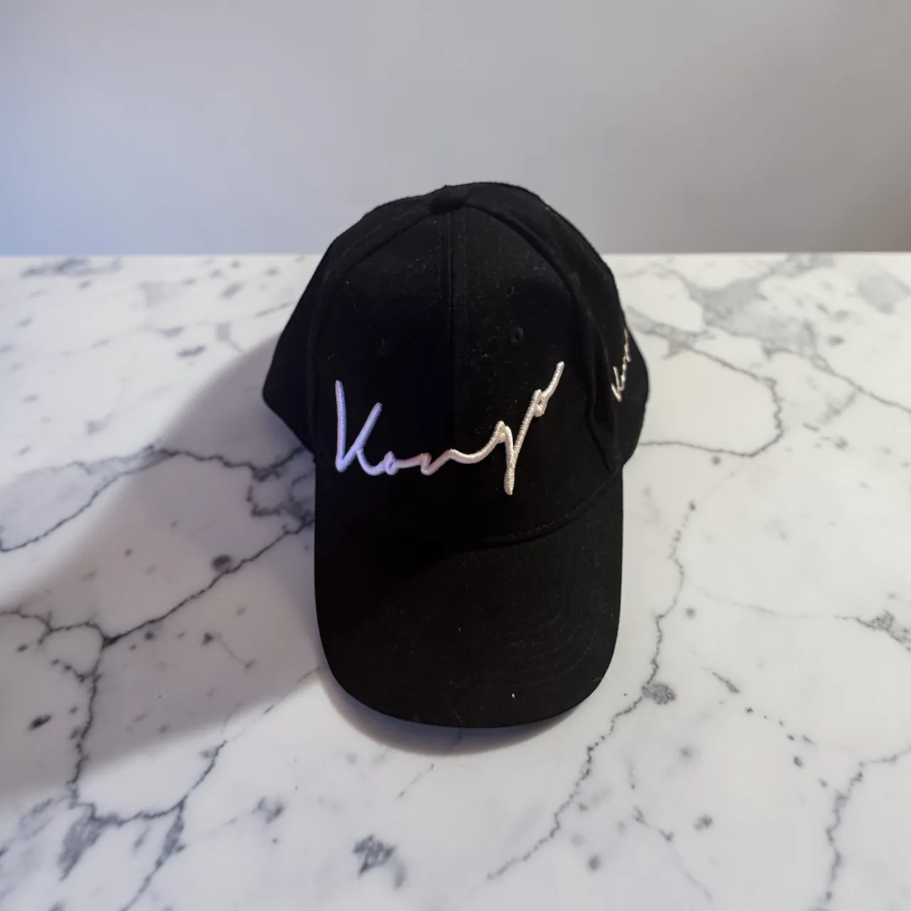 Gorra negra con bordado blanco de la marca "King of the Kongo". Ideal para complementar looks urbanos y casuales.