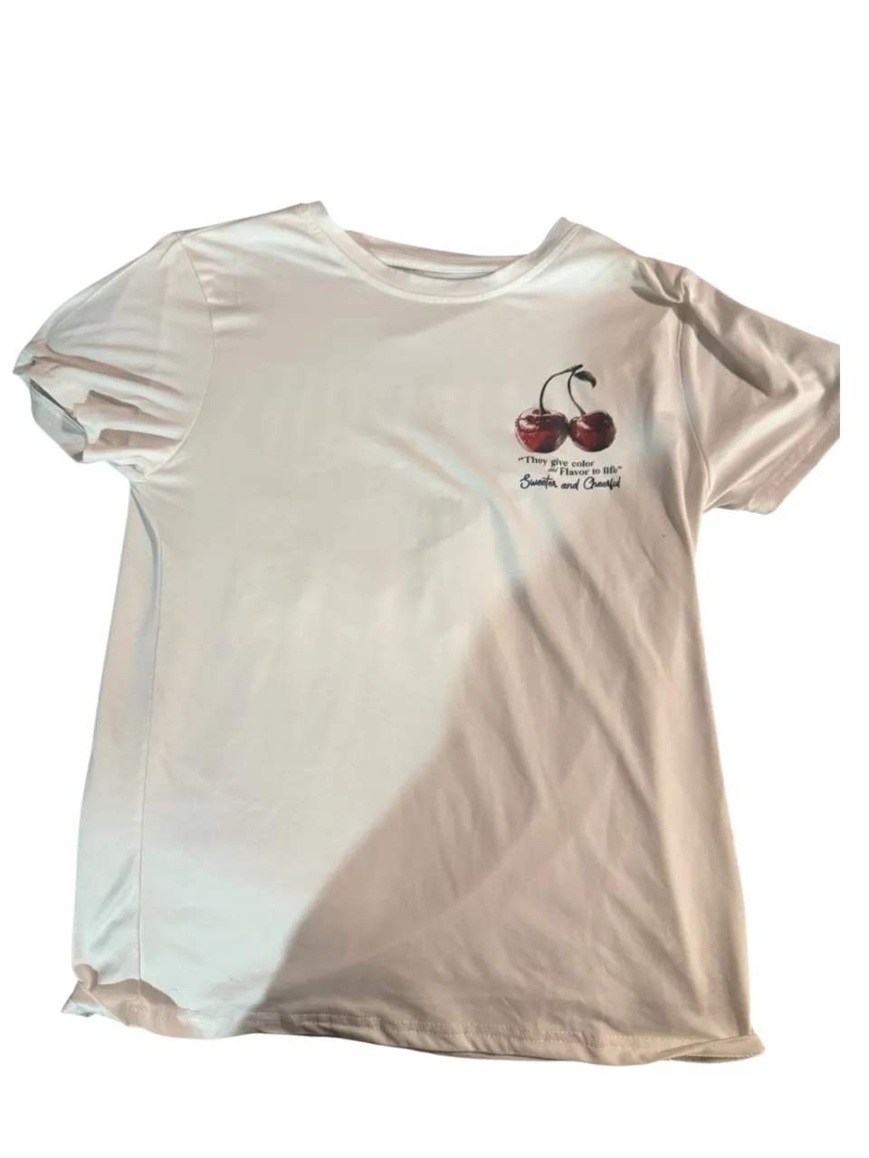 Remera blanca con estampa de cerezas y frase "My friends are my cherries". Ideal para un look casual y divertido.