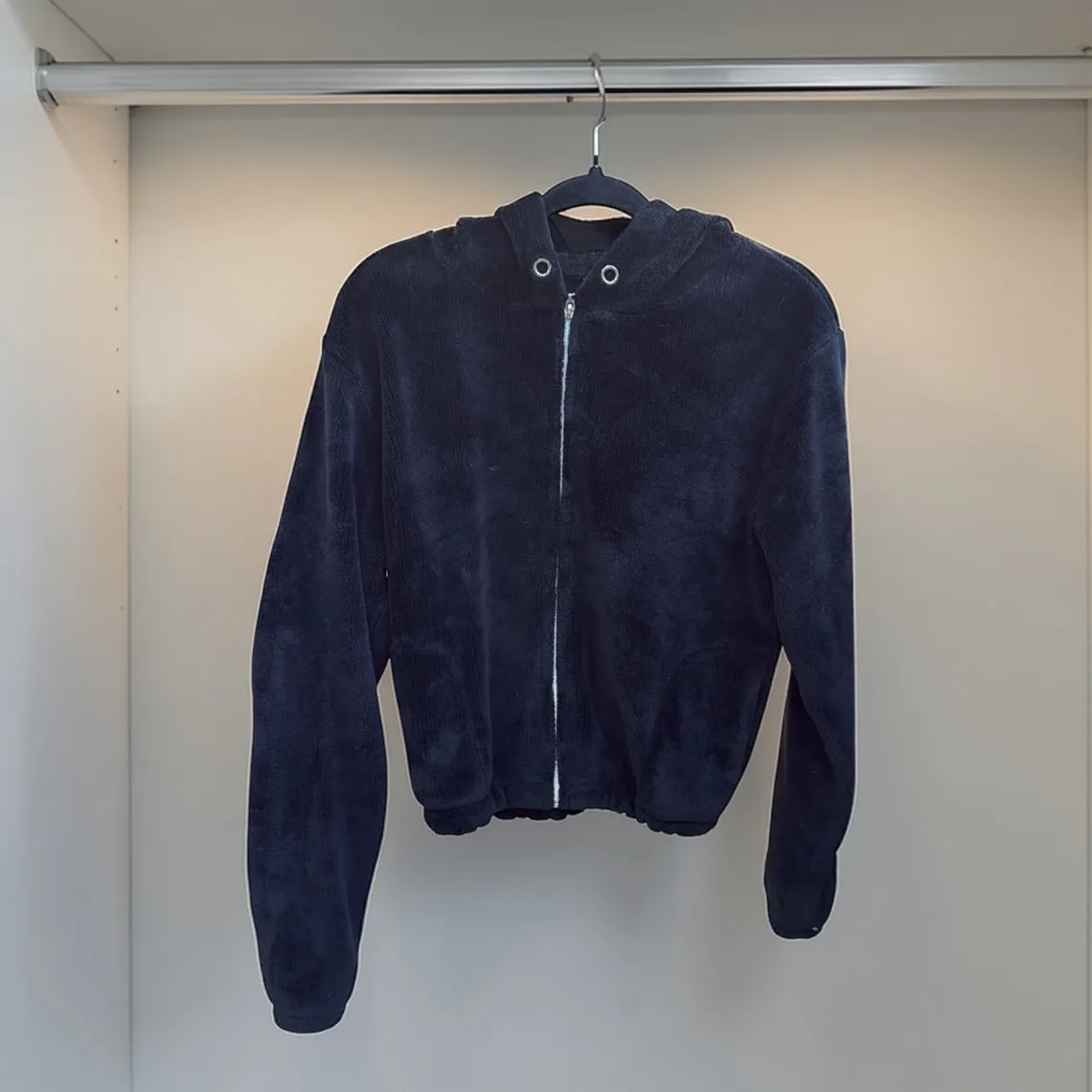 campera de terciopelo con capucha y cierre completo. Puños y cintura elastizados.