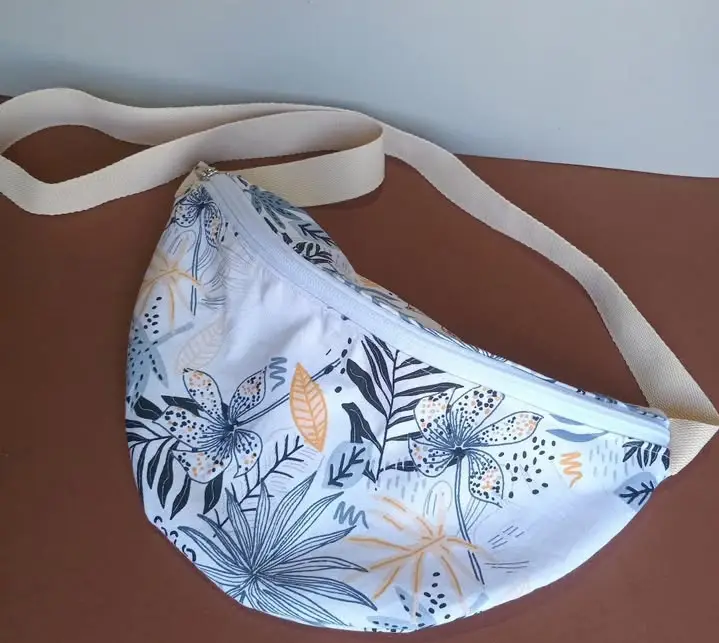 Bandolera con estampado floral en tonos azules y amarillos sobre fondo blanco. Ideal para llevar lo esencial con estilo y comodidad. Perfecta para un look casual y fresco.