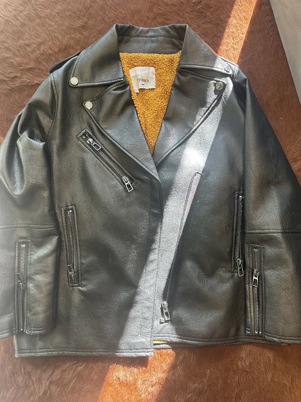 Campera biker de cuero sintético negro con forro interior amarillo. Un clásico del estilo rocker, ideal para un look audaz y canchero. Detalles de cierres y solapas.