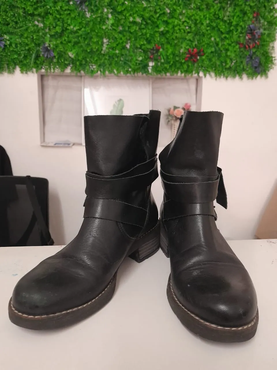 Botas negras de cuero con hebillas y tiras. Caña corta.