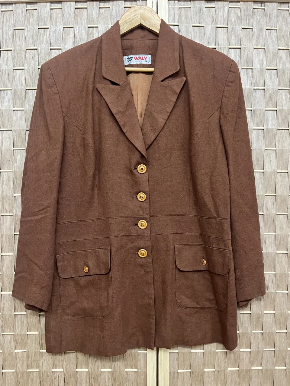 Blazer marrón de corte clásico, ideal para un look formal o de trabajo. Posee botones a tono y bolsillos frontales con tapa.