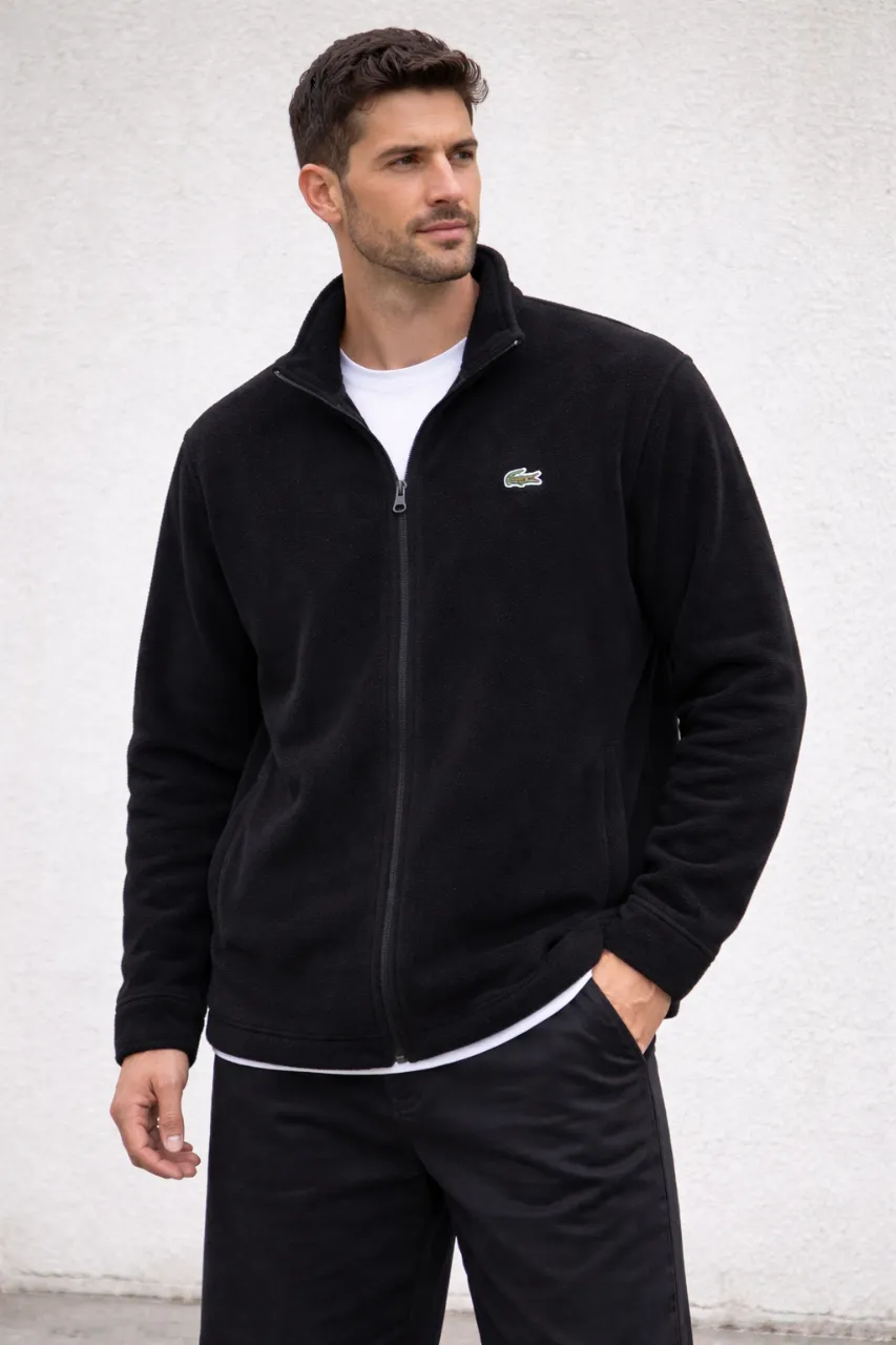 Campera de polar  negra con cierre completo y logo de cocodrilo bordado en el pecho.