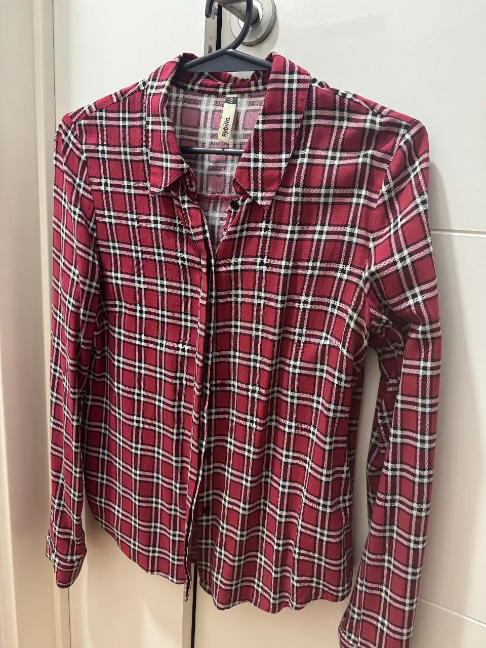 Camisa a cuadros roja y blanca de manga larga, ideal para un look casual y cómodo. Perfecta para usar en cualquier ocasión.