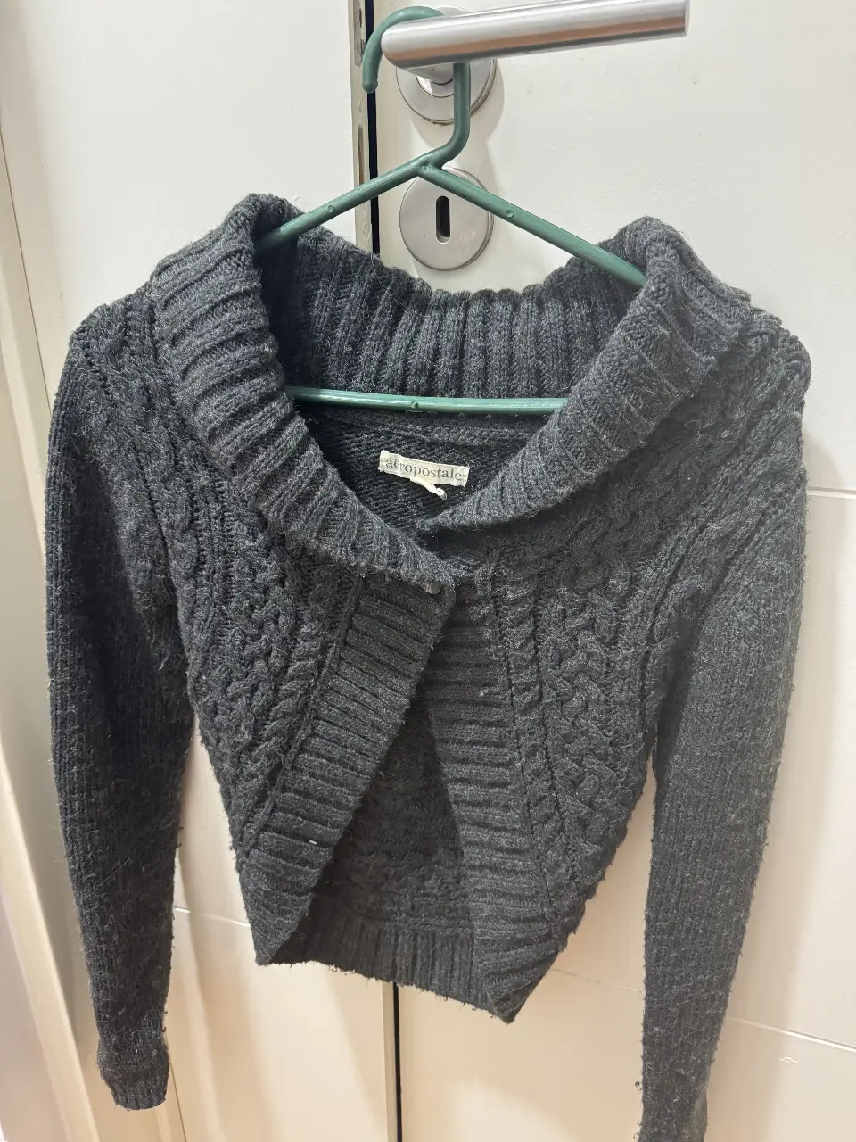 Sweater chaleco gris oscuro de la marca Aeropostale, con cuello amplio y diseño tejido. Ideal para un look casual y abrigado.