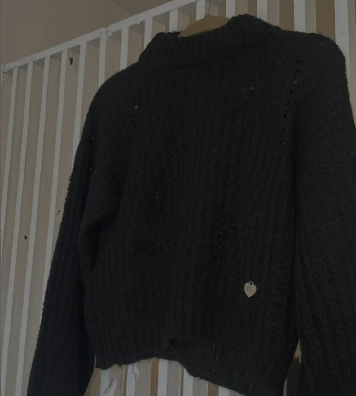 Sweater polera negro de tejido grueso, ideal para el invierno. Con detalle de corazón metálico .