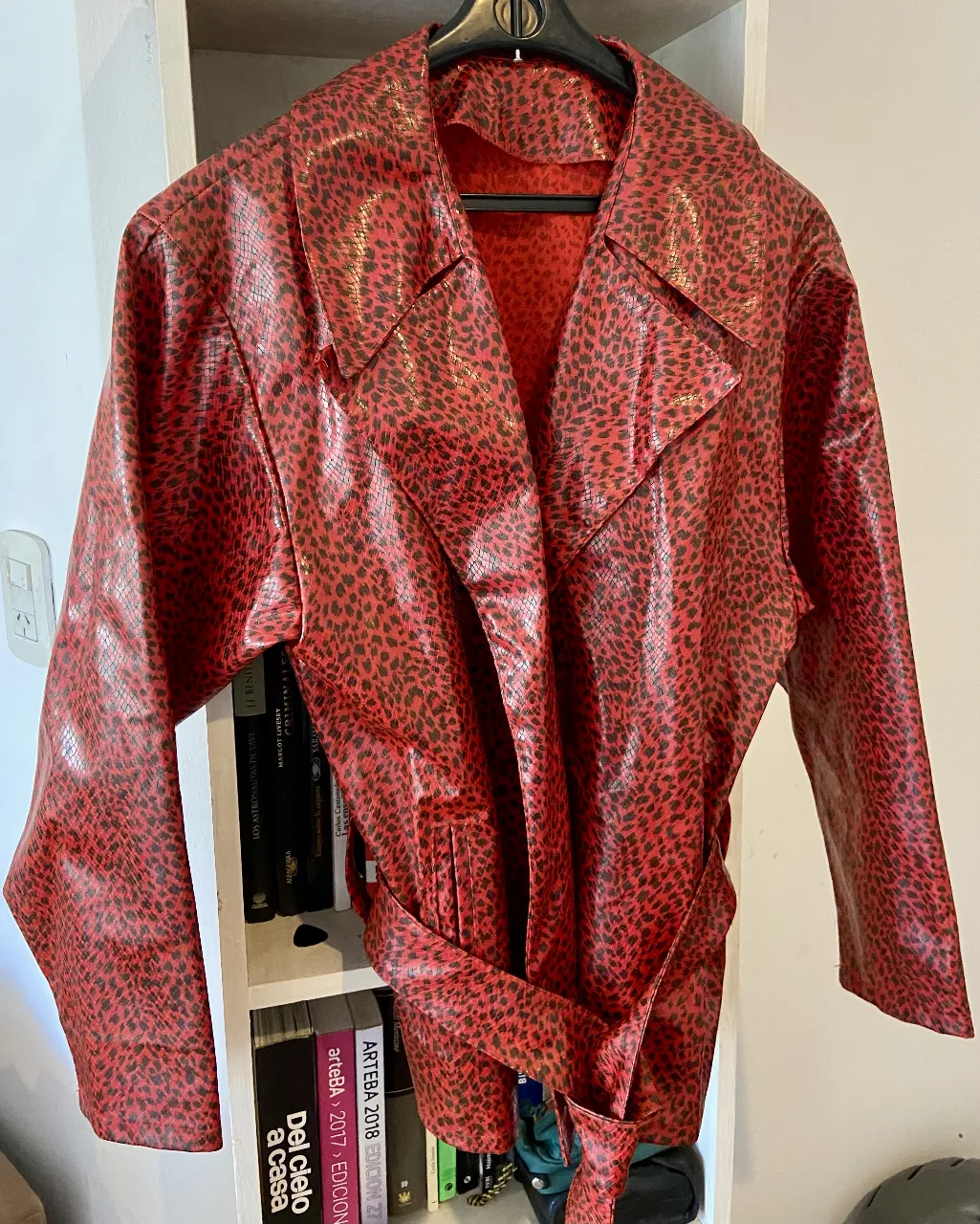 Campera estilo trench con un vibrante estampado animal print en rojo y negro. Un diseño audaz y llamativo, ideal para quienes buscan destacar. Cuenta con un cinturón para marcar la cintura y un corte clásico de trench que nunca pasa de moda. Perfecta para darle un toque de personalidad a cualquier outfit.