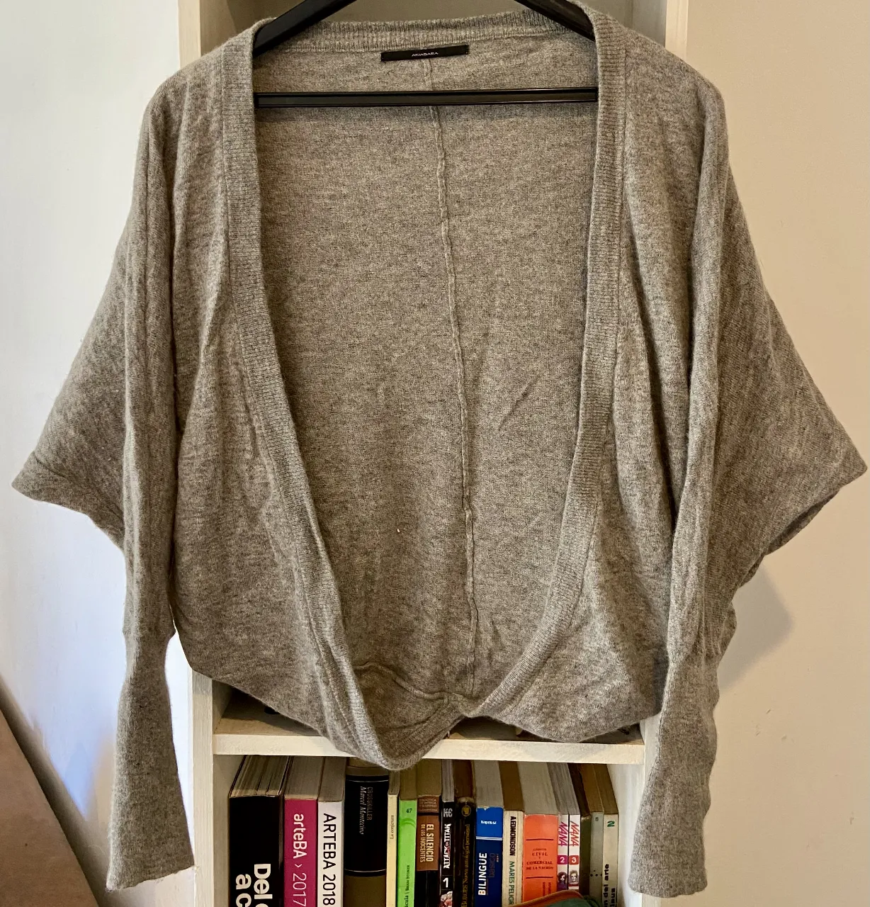 Cardigan de tejido suave en color gris. Diseño abierto con mangas anchas y caídas, ideal para un look cómodo y canchero. Perfecto para usar sobre otras prendas o como una capa ligera.