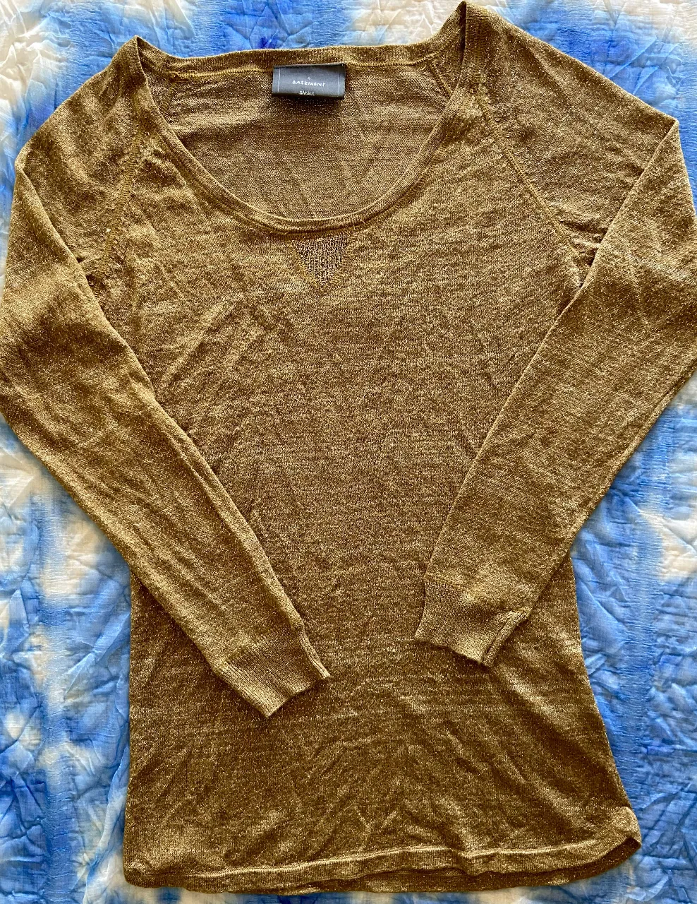 Remera dorada con brillos, manga larga y escote redondo. Perfecta para darle un toque especial a cualquier look.