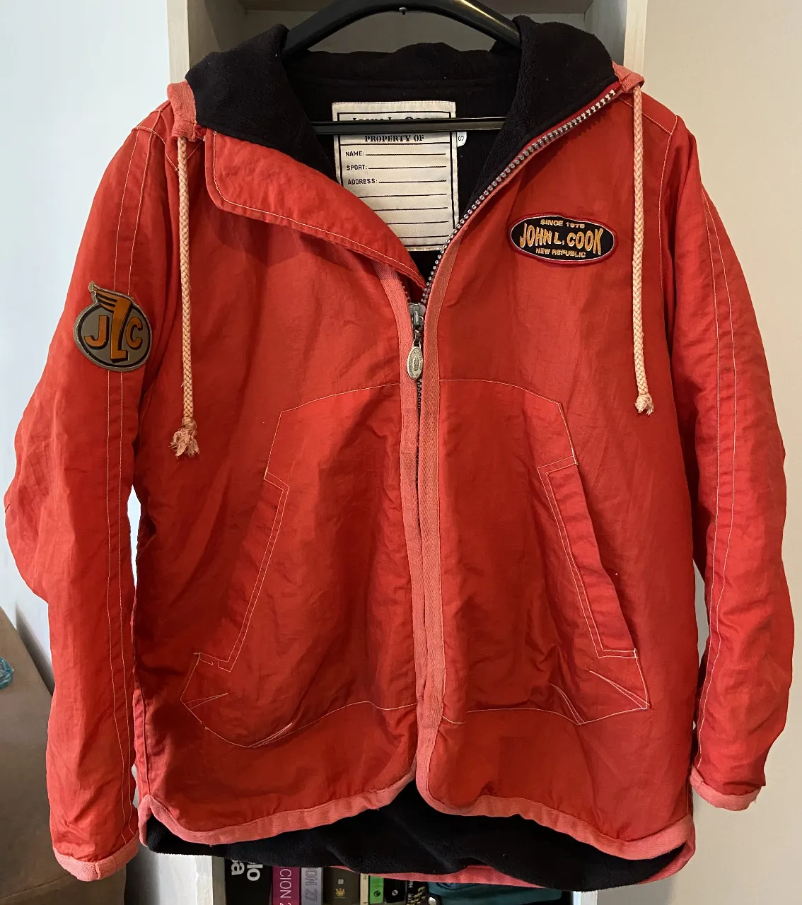 Campera roja/naranja de finales de los 90s. Con capucha, ideal para un look casual y urbano. Posee cordones para ajustar la capucha y bolsillos amplios al frente. 