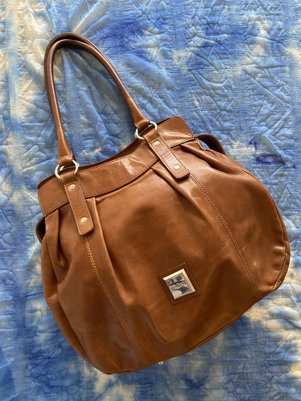 Bolso de cuero marrón, súper práctico y canchero. Tiene un diseño moderno y es ideal para el día a día. Posee 4 bolsillos interiores, todos funcionales 