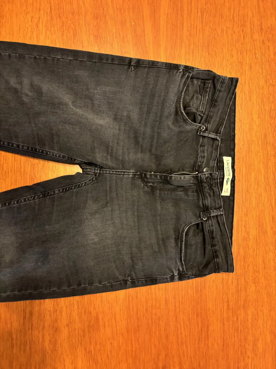 Jeans Lacoste negros tiro alto, corte skinny.