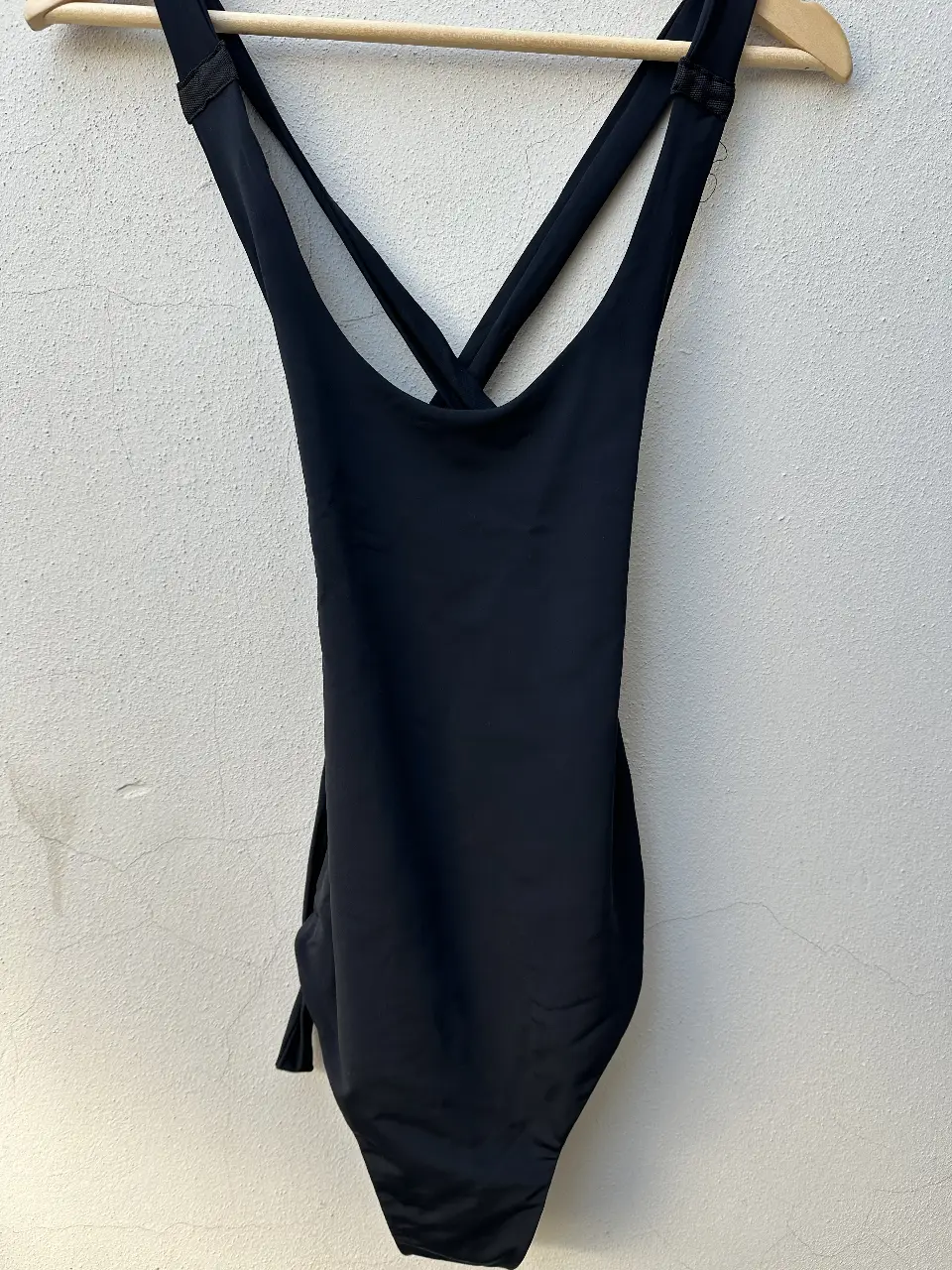Body /Traje de baño enterizo negro de la marca Kostume, con diseño de espalda cruzada y corte cavado. Ideal para la playa o pileta.