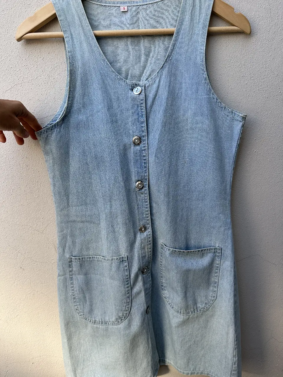 Vestido mini de jean celeste, con botones frontales y bolsillos delanteros. Ideal para un look casual y fresco. sin marca