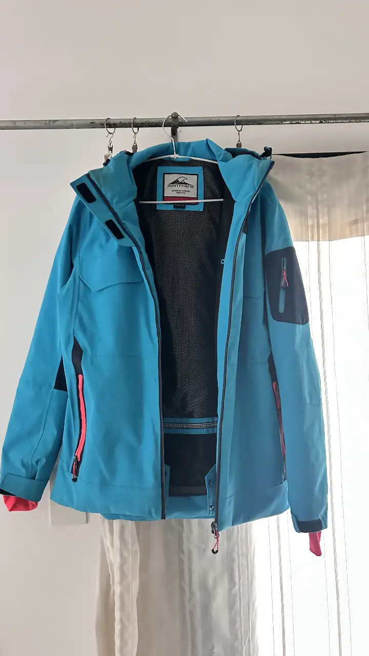 Campera Montagne azul, ideal para actividades al aire libre. Con cierre, bolsillos y detalles en rosa. Talle XL.