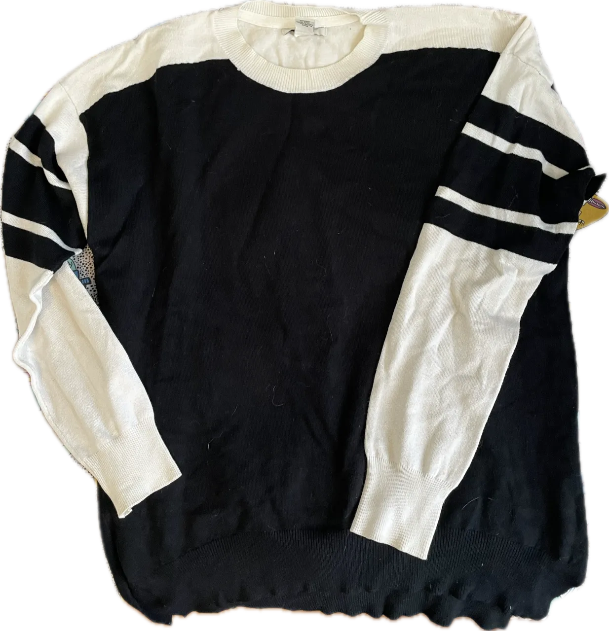 Sweater de tejido fino, con cuello redondo y mangas largas. Diseño bicolor en negro y blanco, con detalles de rayas blancas en las mangas. Ideal para un look casual y moderno.

Largo adelante 60 Largo atras 62 Busto 50 Hombros 53 Ancho debajo 47
 