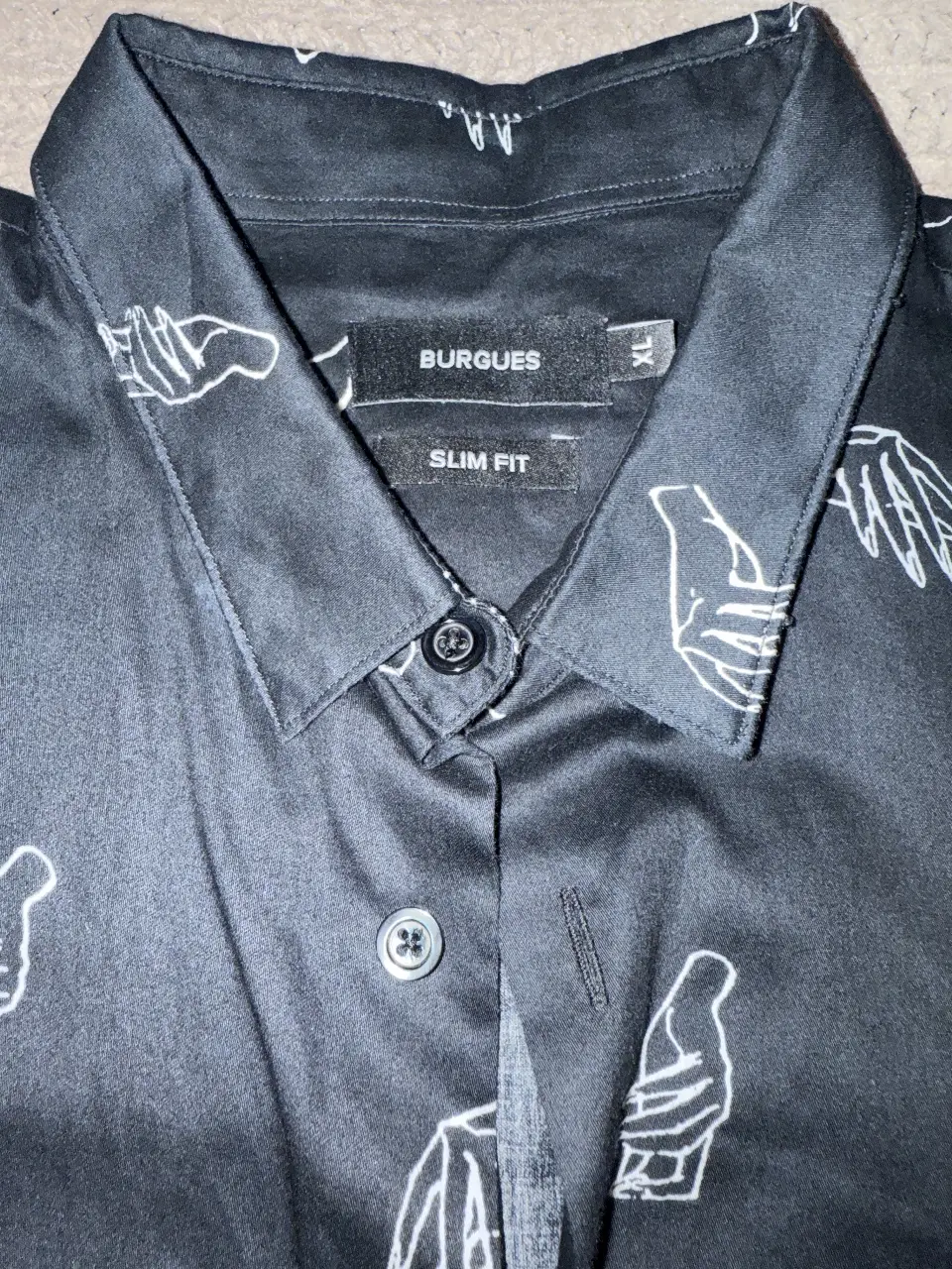 Camisa negra de hombre con estampado de manos blancas, corte slim fit. Ideal para un look casual y con estilo.