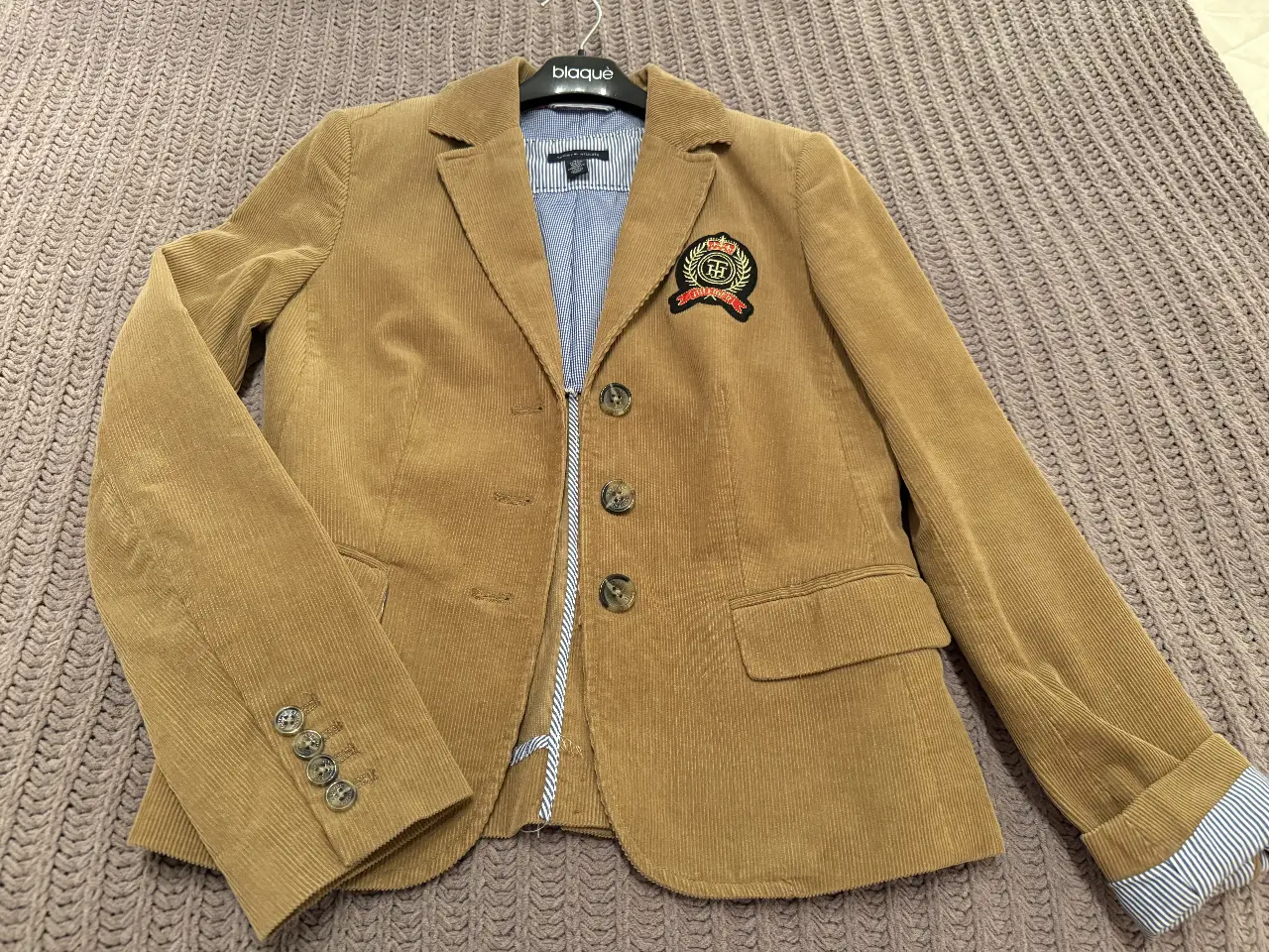 Blazer Tommy Hilfiger de corderoy color marrón, con parche bordado en el pecho. Talle XS.