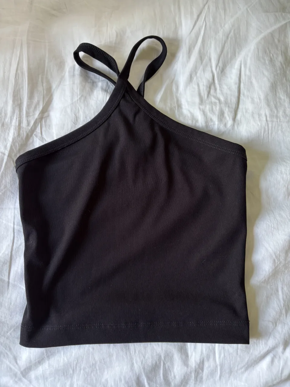 Top negro de breteles finos cruzados en el cuello.