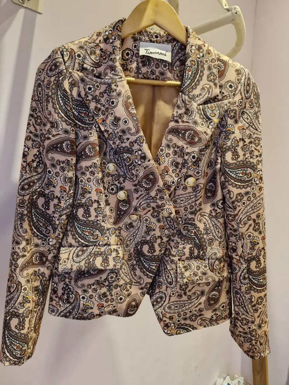 Blazer Timiami con estampado paisley en tonos nude y marrón. Corte entallado, doble botonadura y forro interior. Ideal para un look elegante y sofisticado.