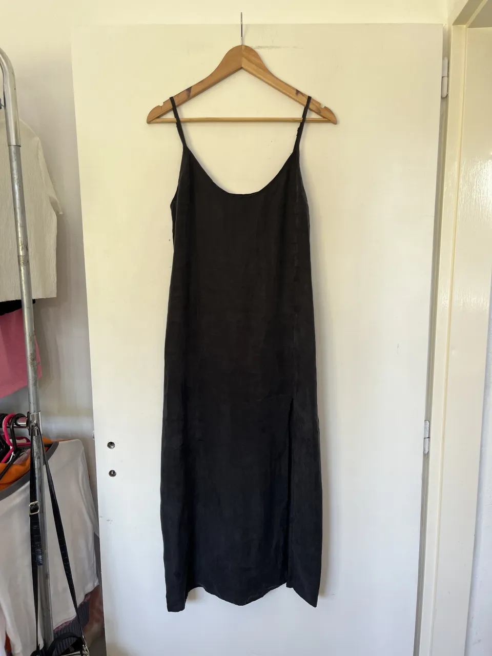 Vestido negro largo con tiras finas y tajo lateral.