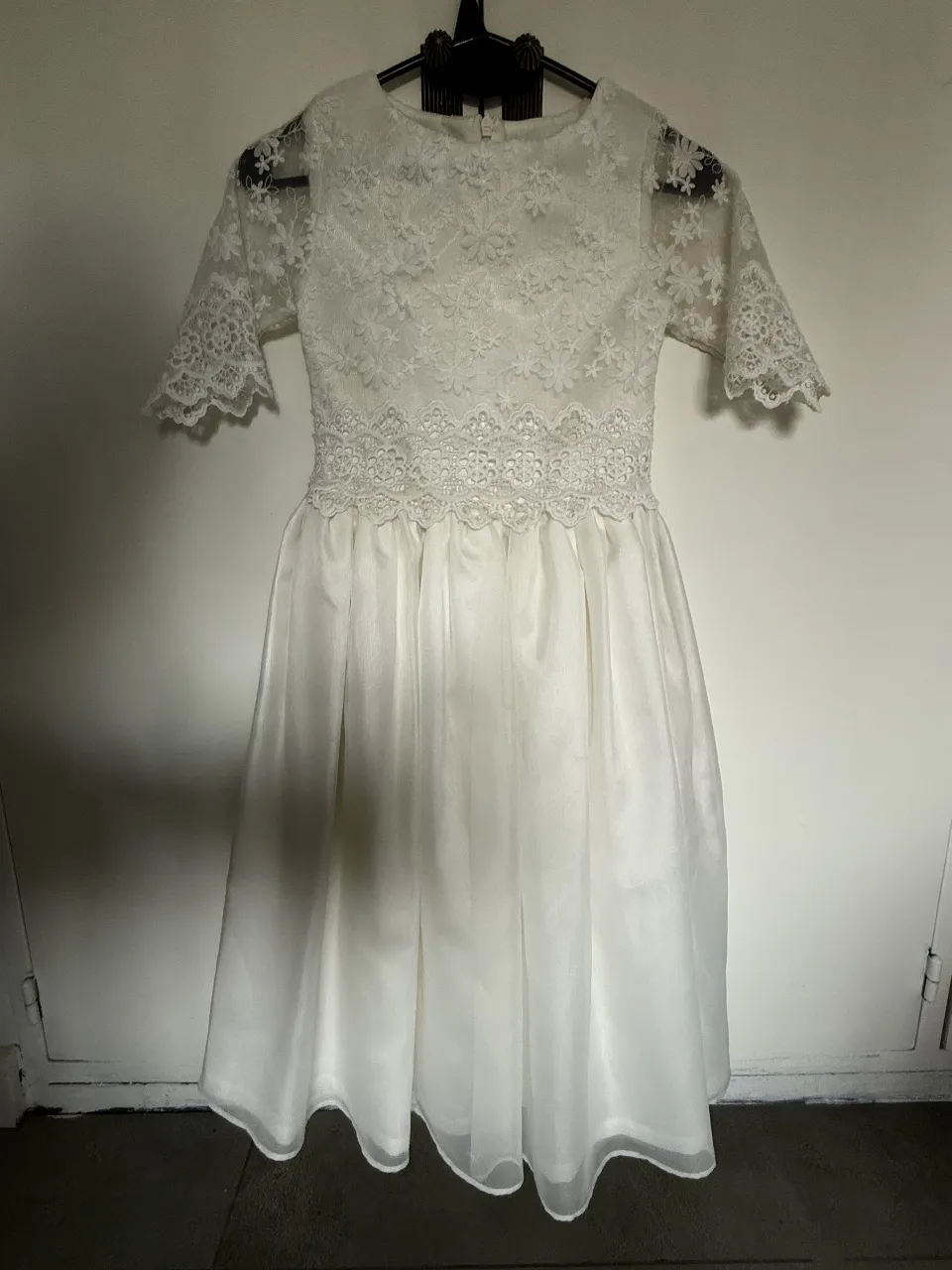 Vestido blanco de encaje con mangas cortas y falda amplia. Ideal para eventos especiales o comuniones.