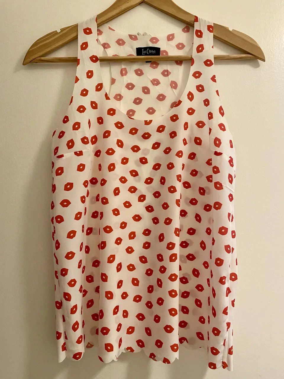 Blusa de mujer con estampado de besos rojos sobre fondo blanco. Diseño sin mangas, y con innovador corte láser (terminaciones sin costuras) ideal para el verano. Marca Las Oreiro.