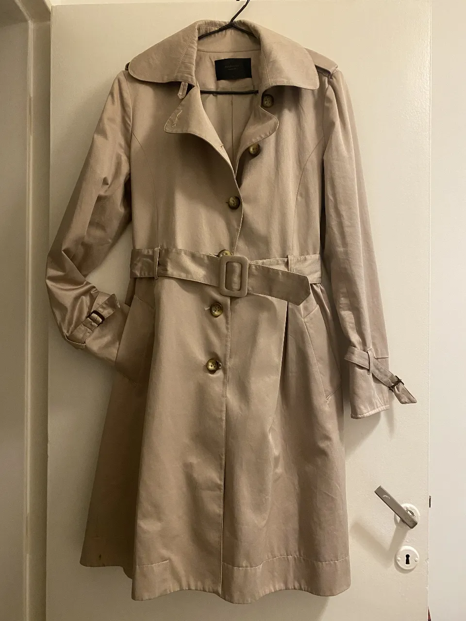 Trench coat color crudo, con cinturón y botones dorados. Ideal para un look elegante y sofisticado. talle 40 de sastrería EU