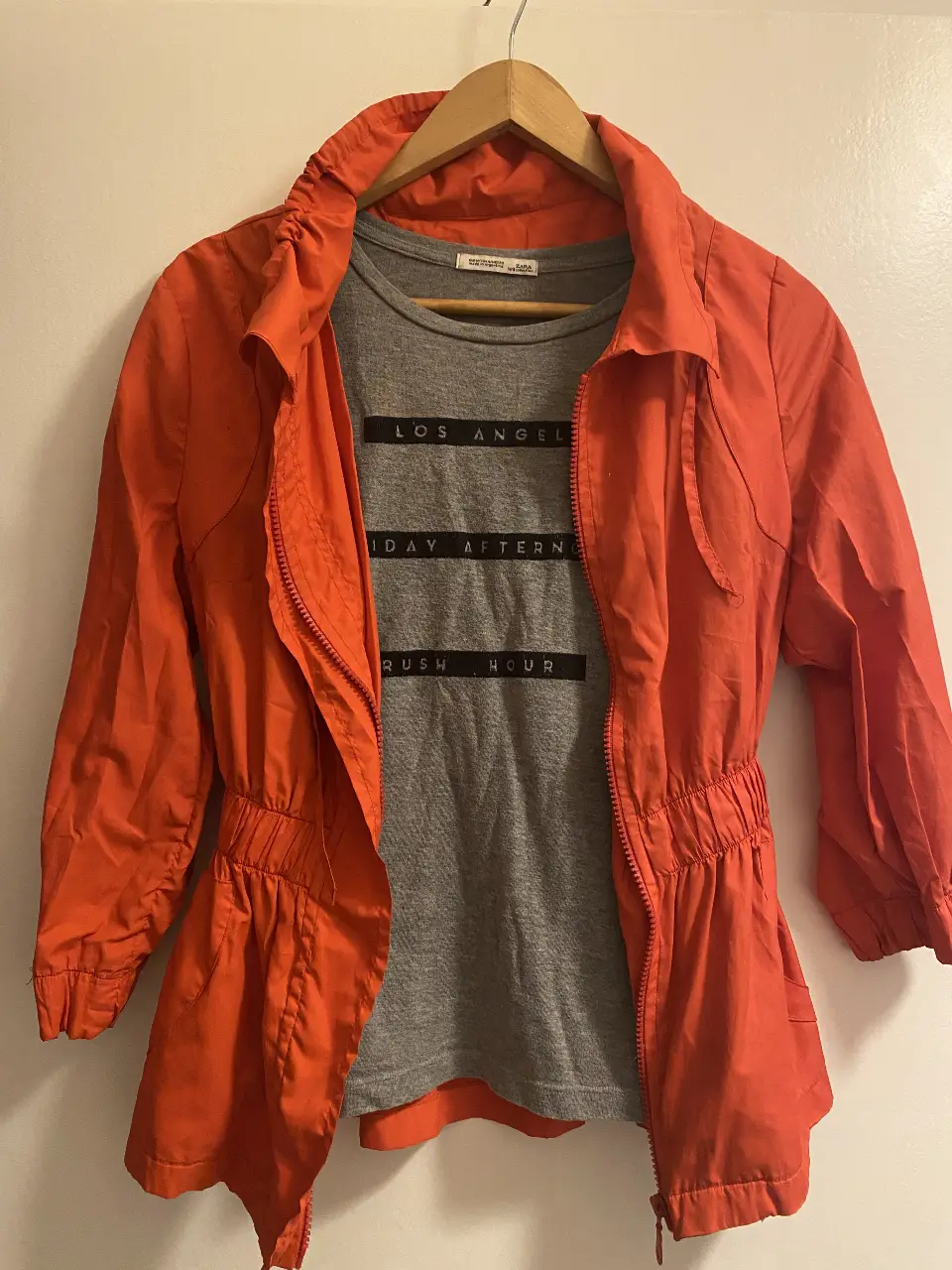 Campera naranja con cierre y cintura elastizada. Posee bolsillos y mangas 3/4. Ideal para un look casual y moderno.