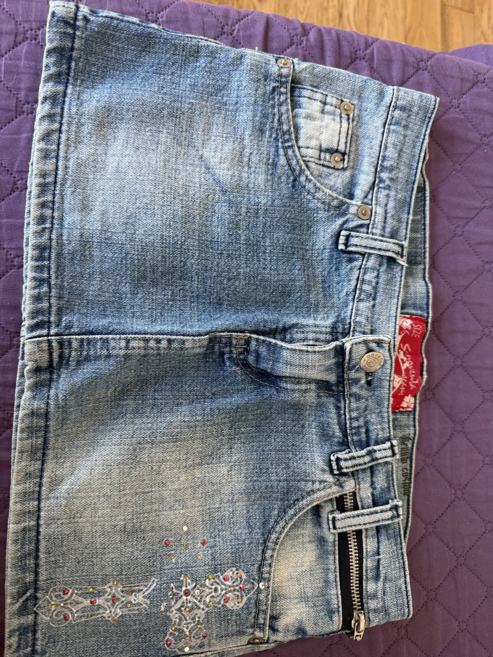 Pollera de jean  vintage tiro bajo con detalles de strass y bordados. Un diseño único y canchero para lucir esta temporada. Ideales para un look relajado y con onda.