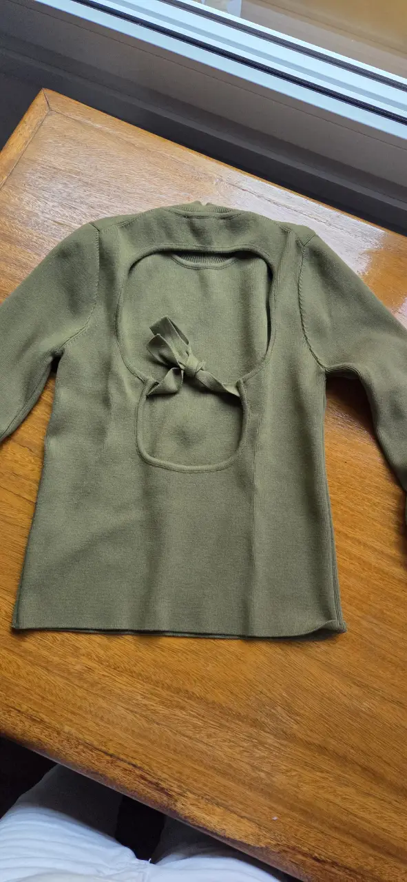 Sweater de cuello alto con abertura en la espalda y detalle de lazo. Ideal para un look moderno y sofisticado.