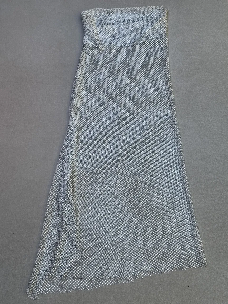 Vestido largo plateado, ideal para fiestas o eventos especiales. Su diseño de red con brillos le da un toque glamoroso y moderno, perfecto para destacar en cualquier celebración.

Tiene detalle, la costura en la última foto