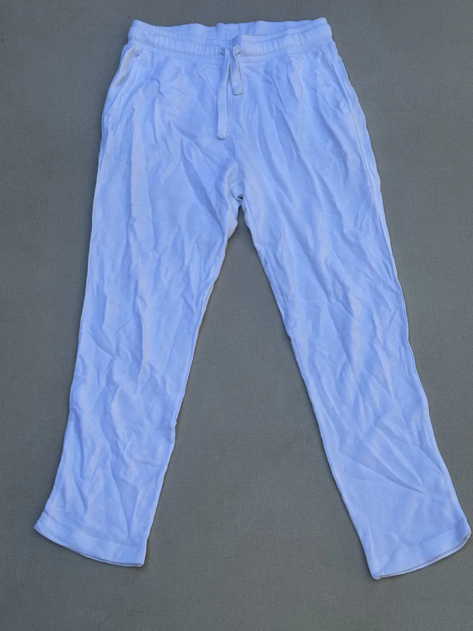 Pantalón blanco de algodón, tiro alto, con cordón ajustable en la cintura y bolsillos. Ideal para un look cómodo y casual.

Detalle: manchado en el lugar de las fotos