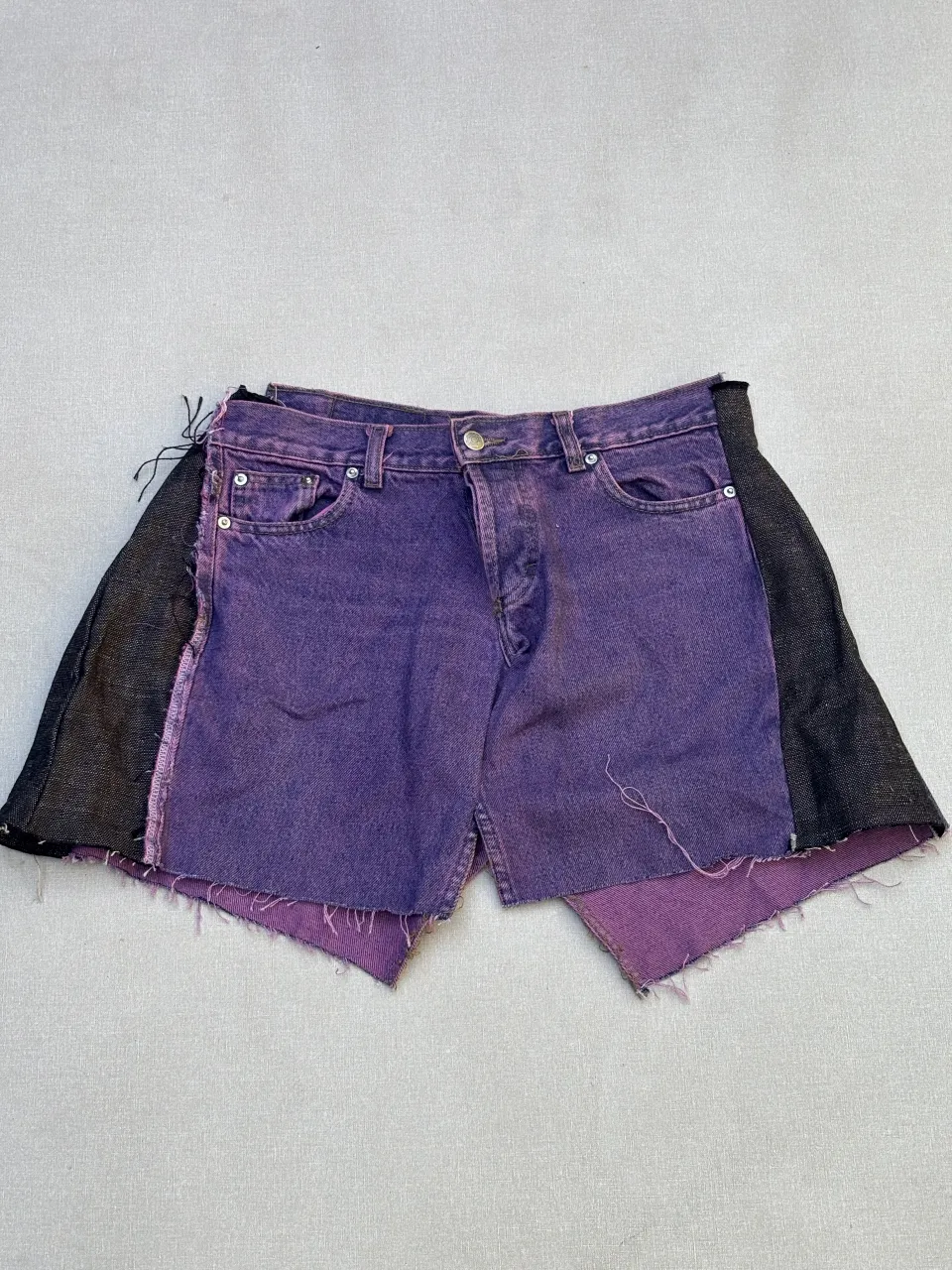 Shorts de jean intervenidos, color violeta con detalles en negro. Un diseño único y original para destacar tu estilo.