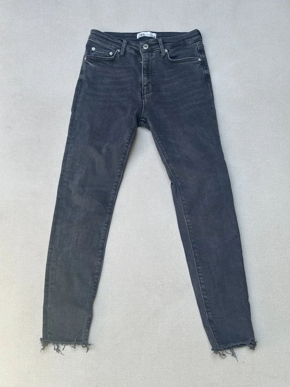 Jean, corte recto y con roturas desflecadas en los tobillos. Un básico canchero para tu día a día.