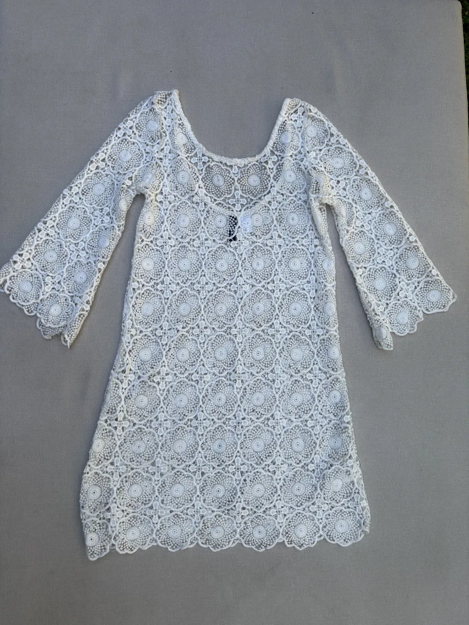 Vestido blanco de encaje con mangas acampanadas y escote redondo. Ideal para un look playero o de verano.

Detalle: es US 6 no está el talle para ponerlo