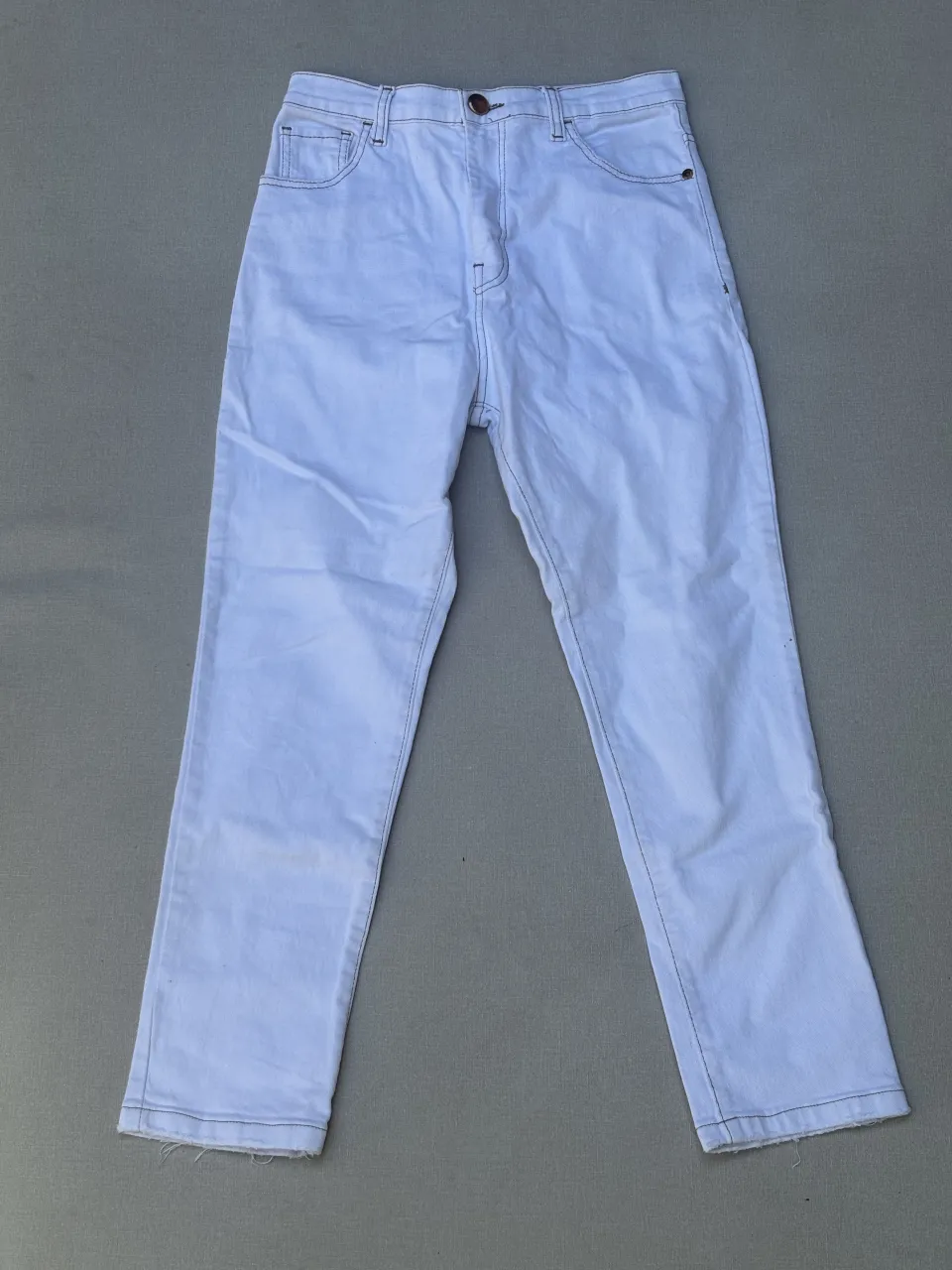 Jeans blancos tiro alto, corte recto y con detalles de costuras a la vista. Un básico versátil para cualquier look.