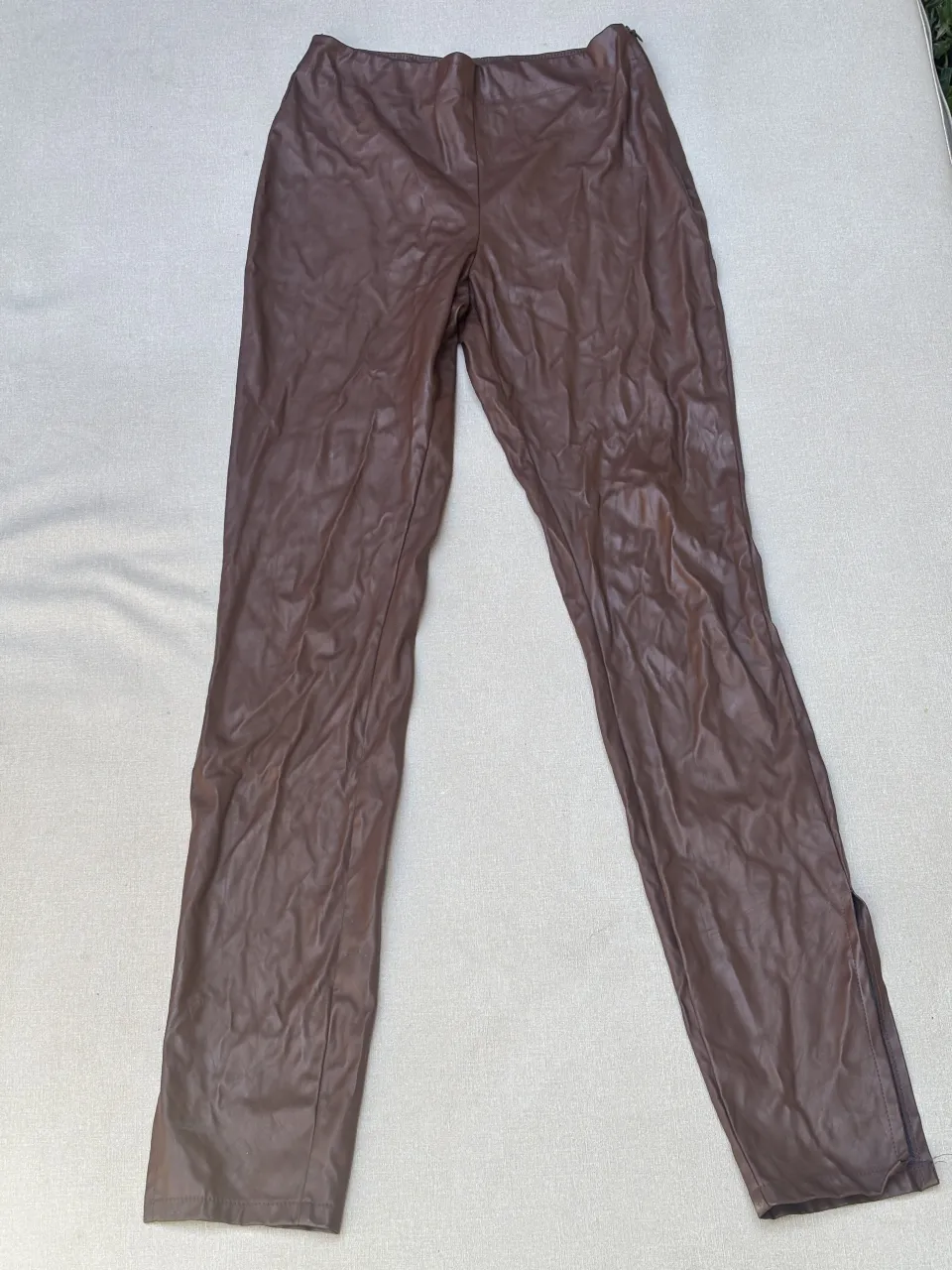 Pantalon de cuero sintético marrón, tiro alto, con tajos en los tobillos. Un básico súper canchero para elevar cualquier look.