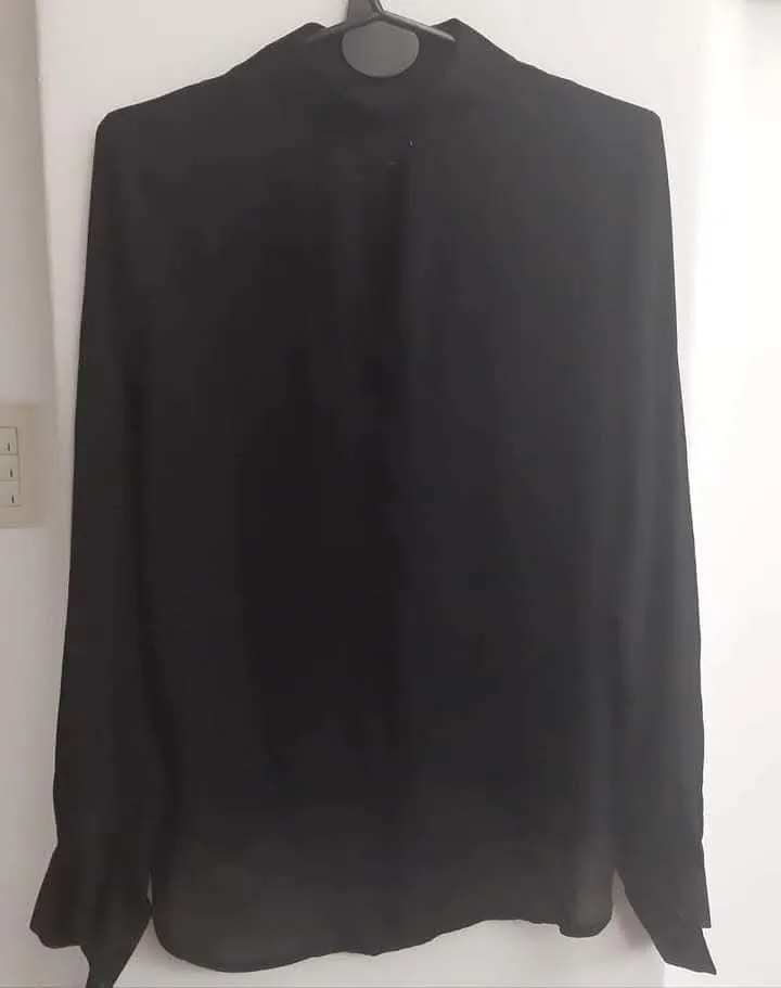 Blusa Brooksfield negra de manga larga con cuello alto y botones en los puños. Ideal para un look elegante y sofisticado.