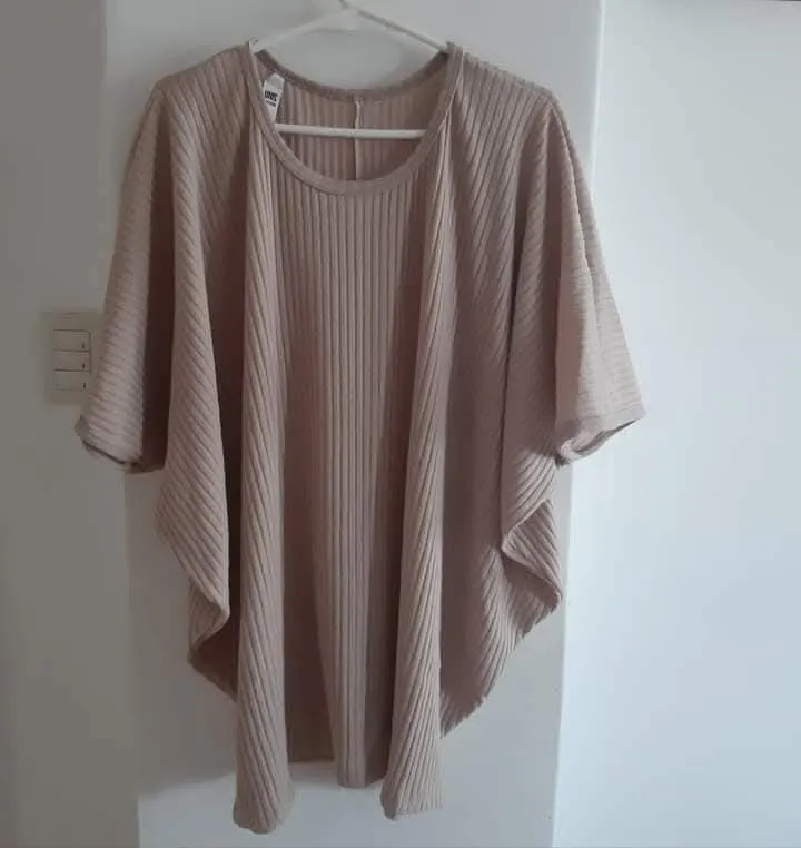 Sweater oversize largo de tejido liviano y suave, ideal para un look relajado y cómodo. Confeccionado en un tono crudo neutro, este sweater es perfecto para combinar con diferentes outfits. Su diseño holgado y mangas amplias lo convierten en una prenda versátil para cualquier ocasión.