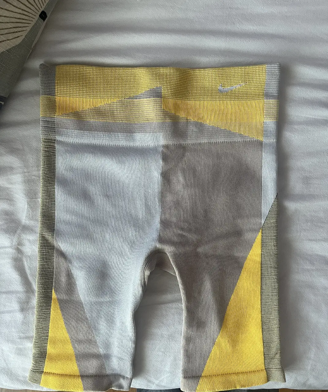 Biker Nike de mujer, color gris con detalles en amarillo. Talle M. Ideal para entrenamientos.