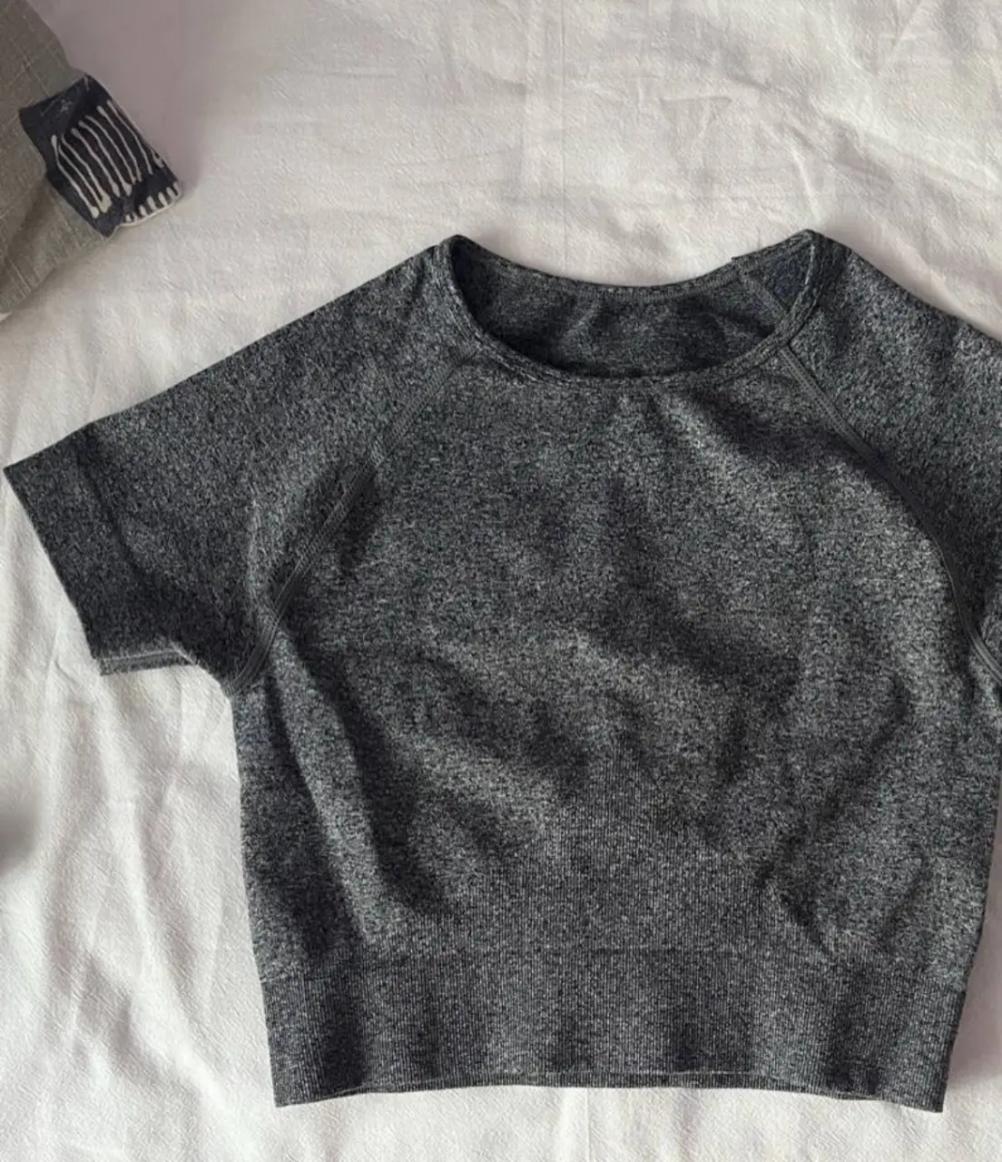 Remera deportiva de manga corta para mujer, color gris. Ideal para entrenamientos y actividades físicas. Diseño cómodo y transpirable.