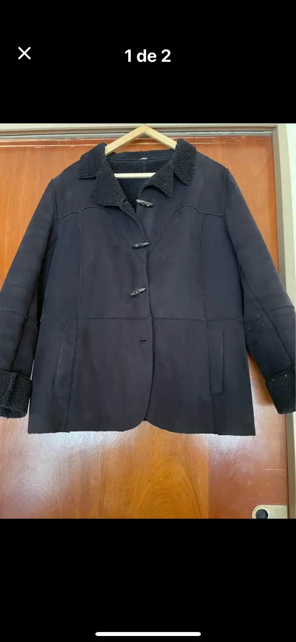 Campera de hombre de color negro, con cuello y puños de piel sintética. Posee botones y bolsillos.