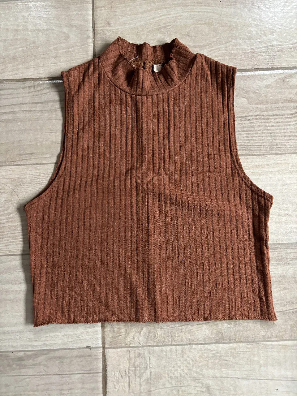 Top sin mangas con cuello alto. Ideal para un look casual y moderno.