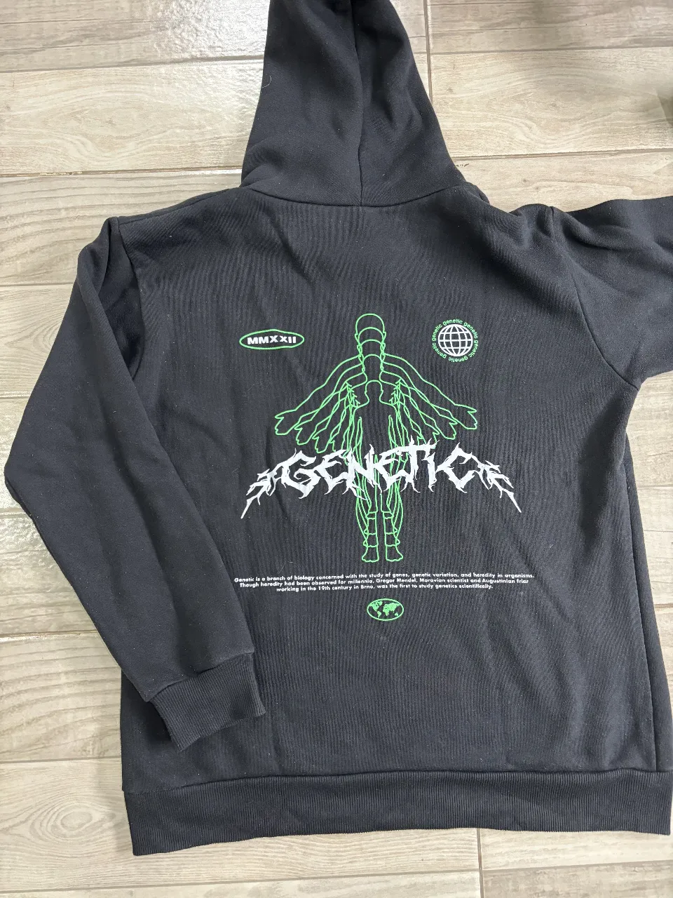 Buzo canguro negro frizado  con capucha y bolsillo. Con diseño en la espalda. 