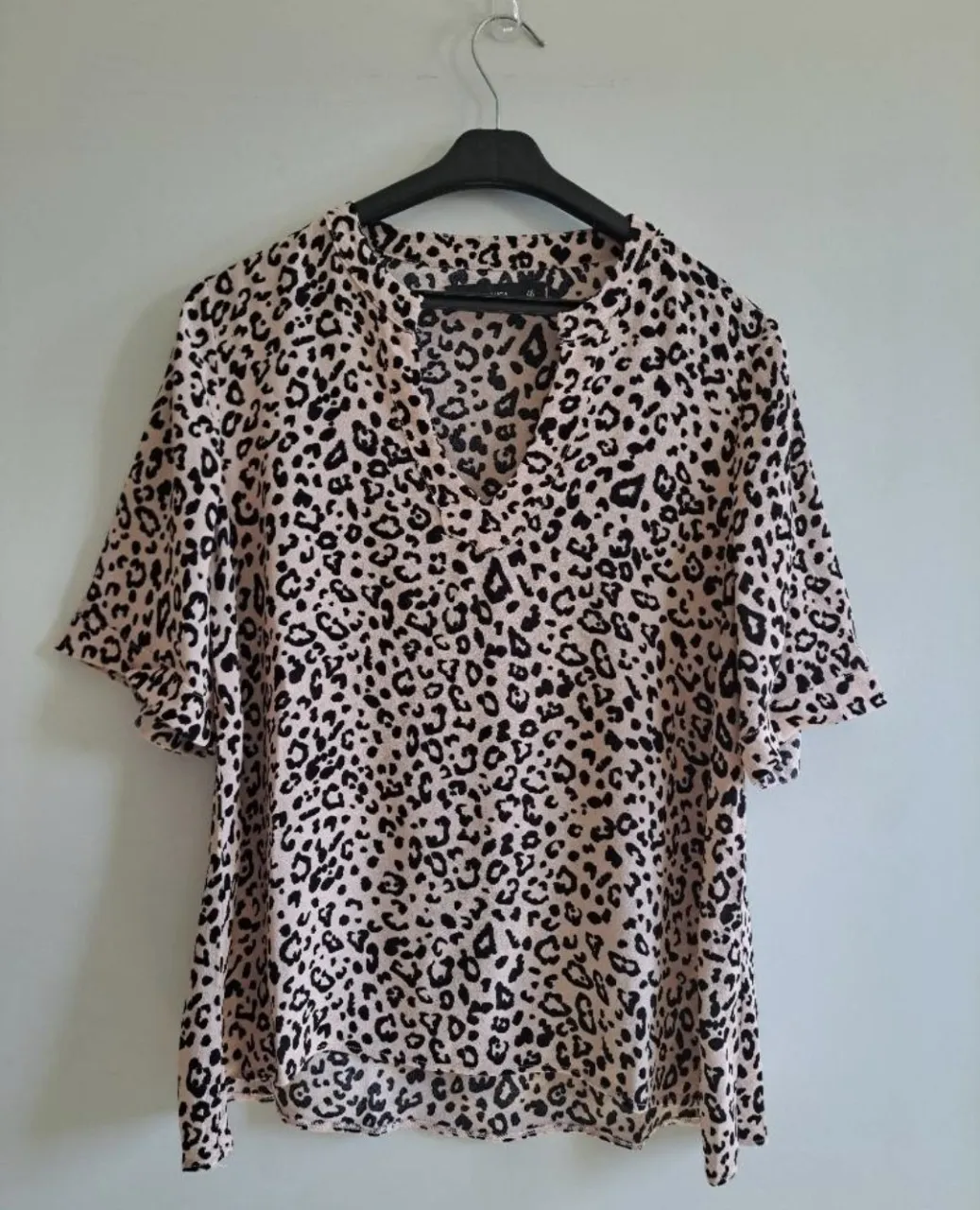 Blusa con estampa de leopardo en tonos rosa pálido y negro. Posee mangas cortas y escote en V. - Talle 46-